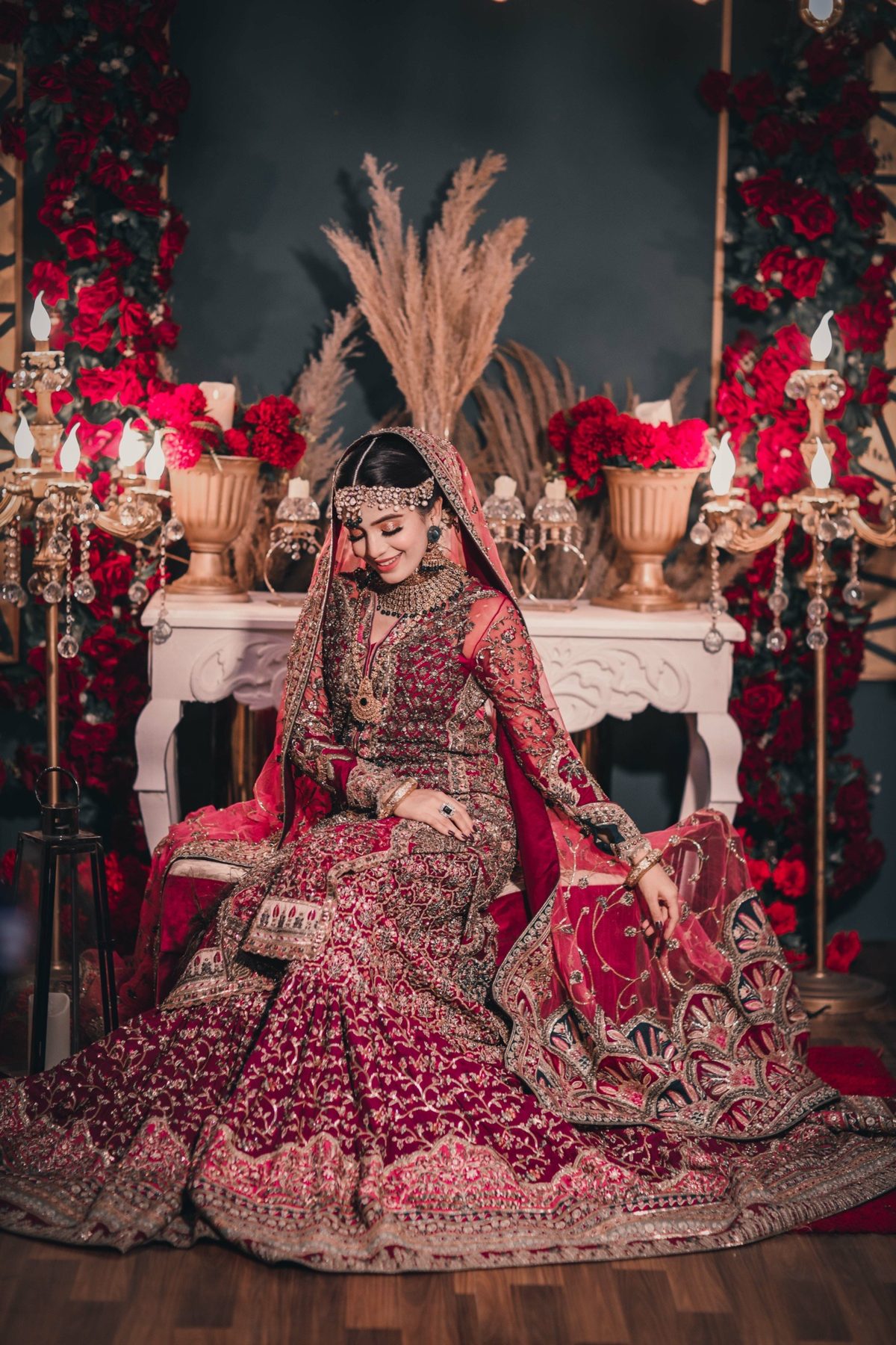 Bride in crimson bridal wear on a floral vintage stage