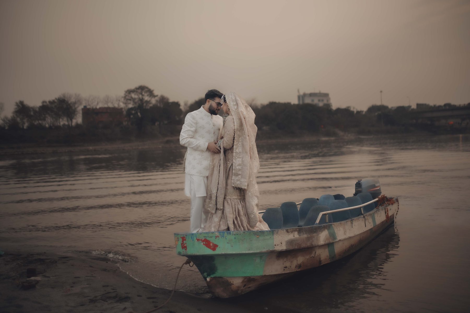 Couple on a wooden boat in soft morning mist