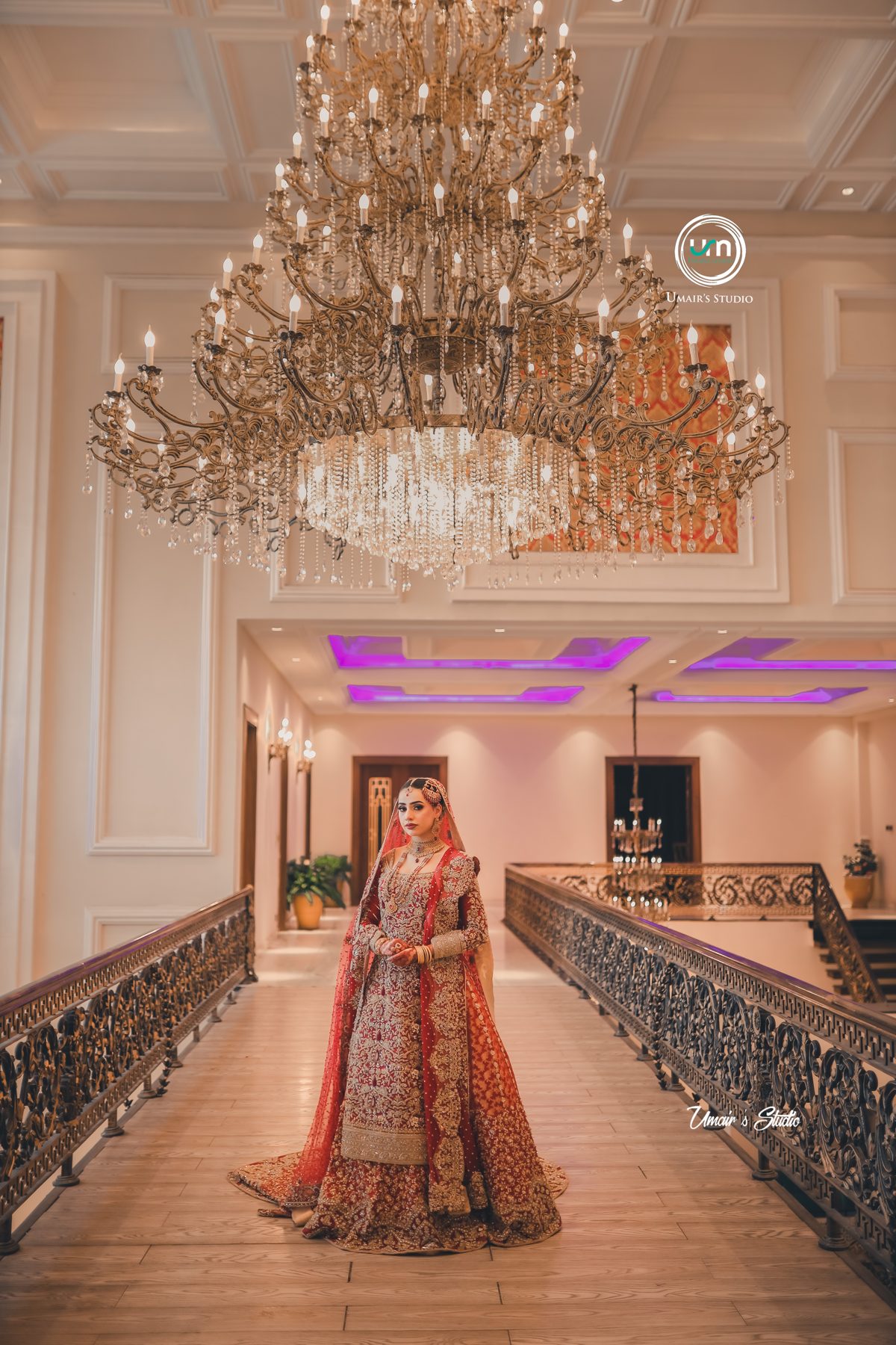 Bride walking down a chandelier-lit banquet hall aisle